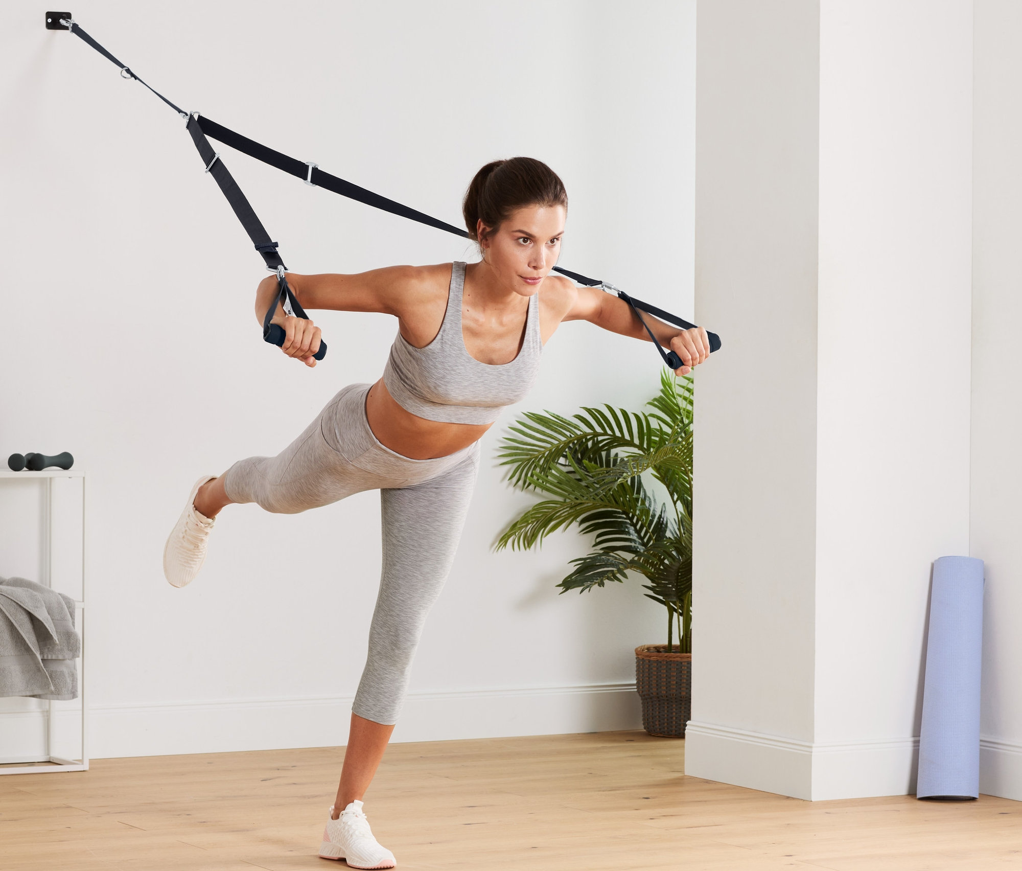 Frau trainiert mit dem Schlingentrainer.