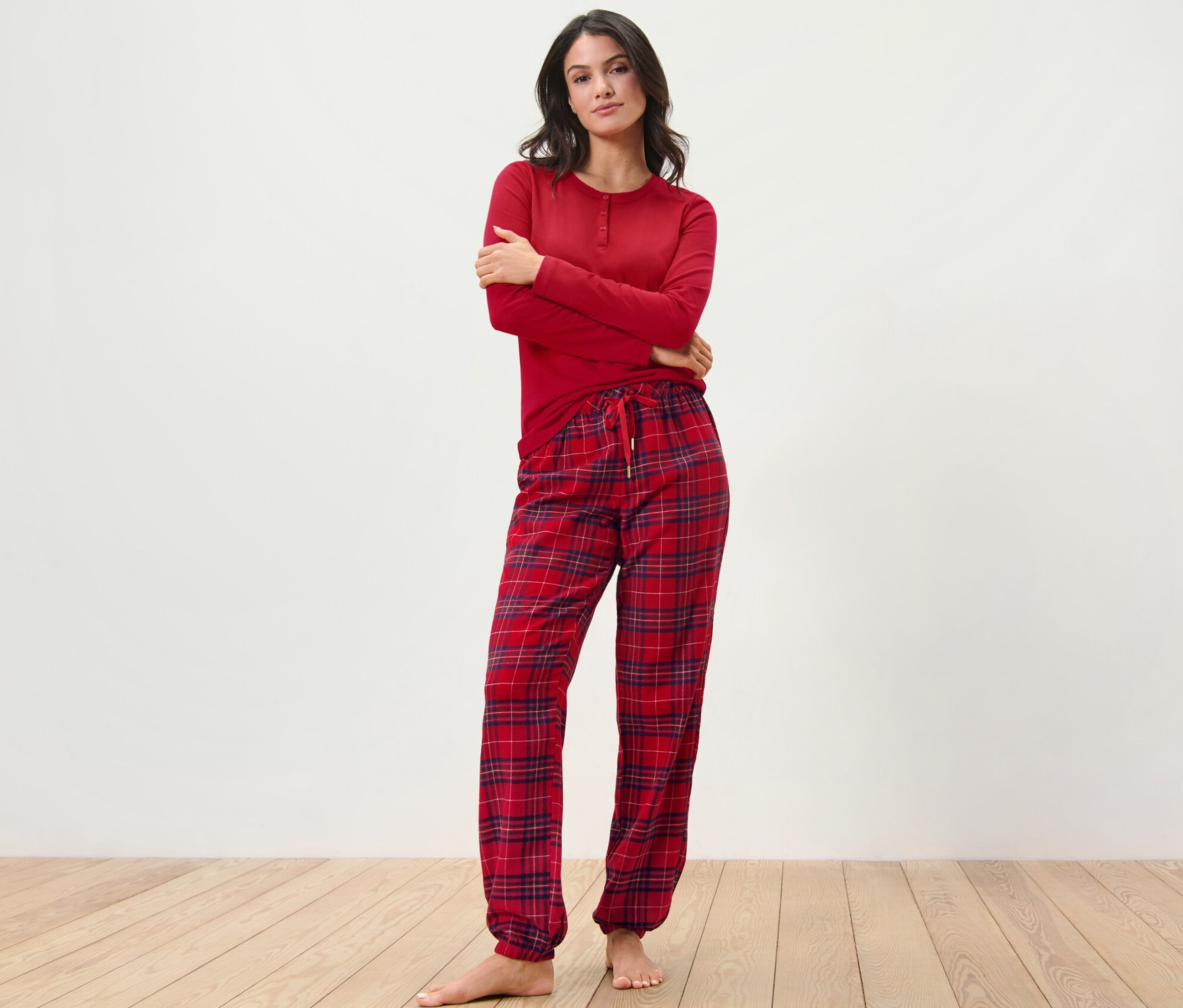 Frau posiert in einem roten Flanell-Pyjama, kariert.