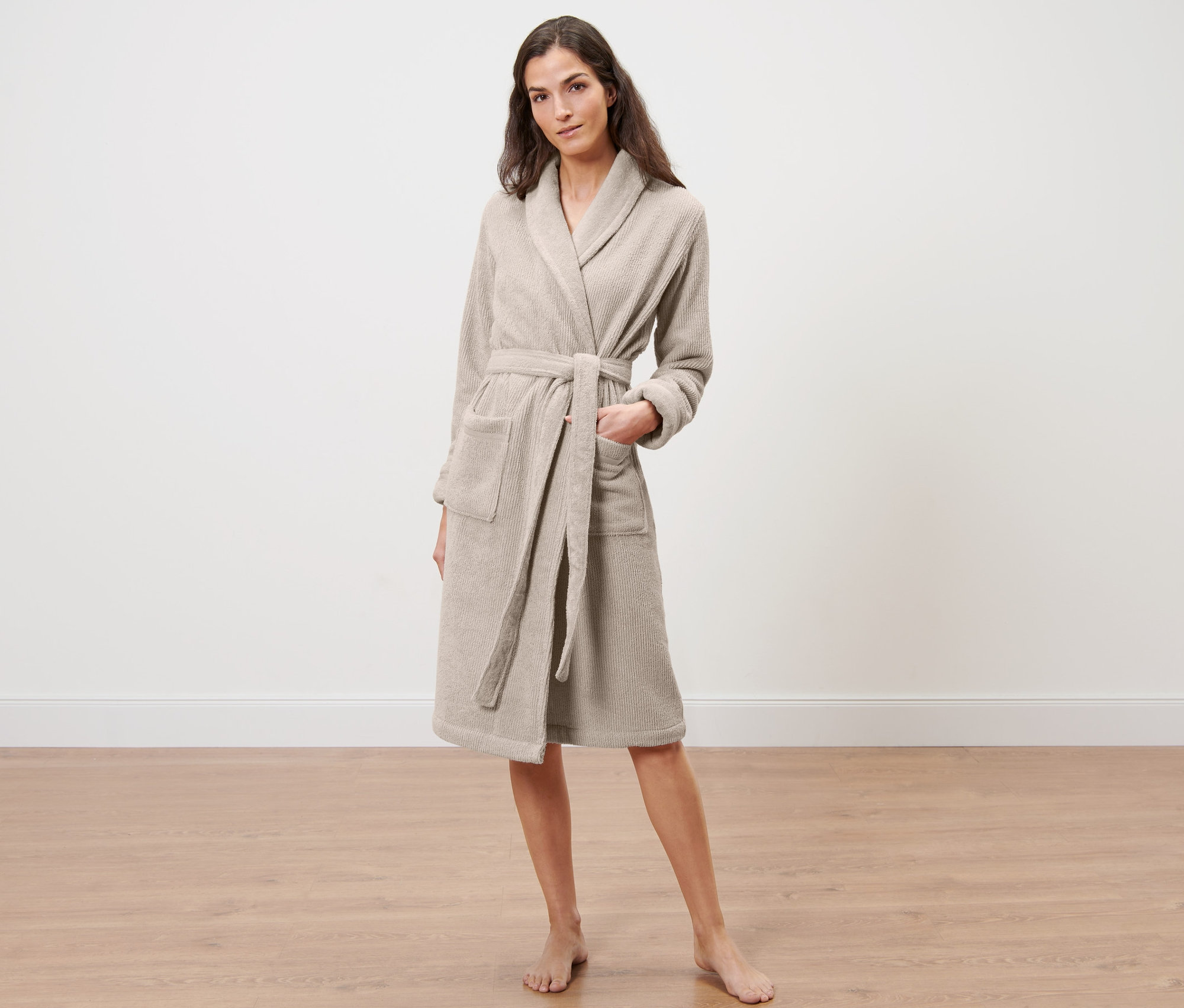 Frau steht und trägt einen Damen-Bademantel.