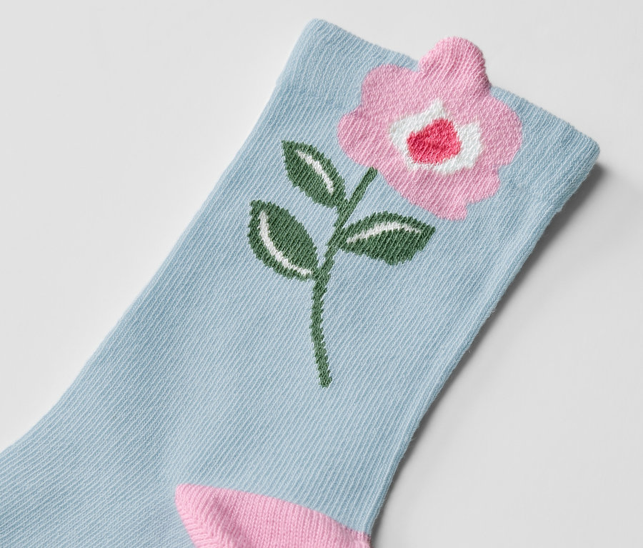 Detailaufnahme einer Kinder-Socke mit Blumenmuster.