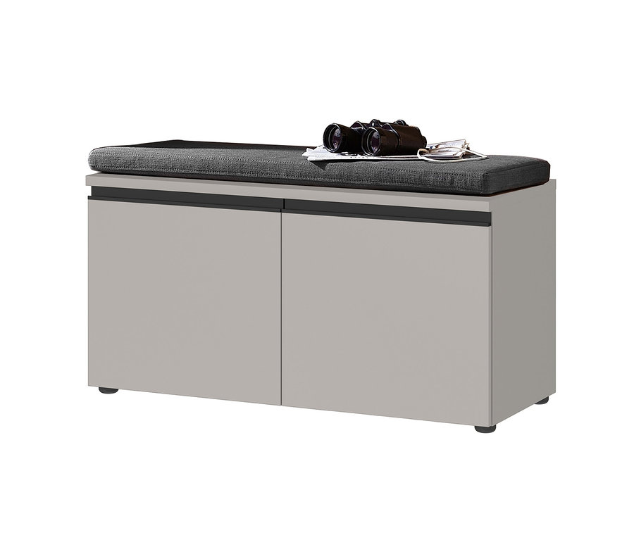 Graue Schuhbank mit grauem Sitzkissen, darauf ein Fernglas und eine Zeitung.