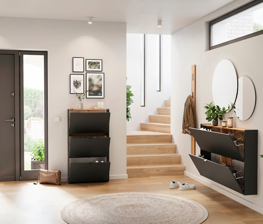 Flur-Interieur mit schwarzen Schuhschränken, Spiegeln und einer Holztreppe.