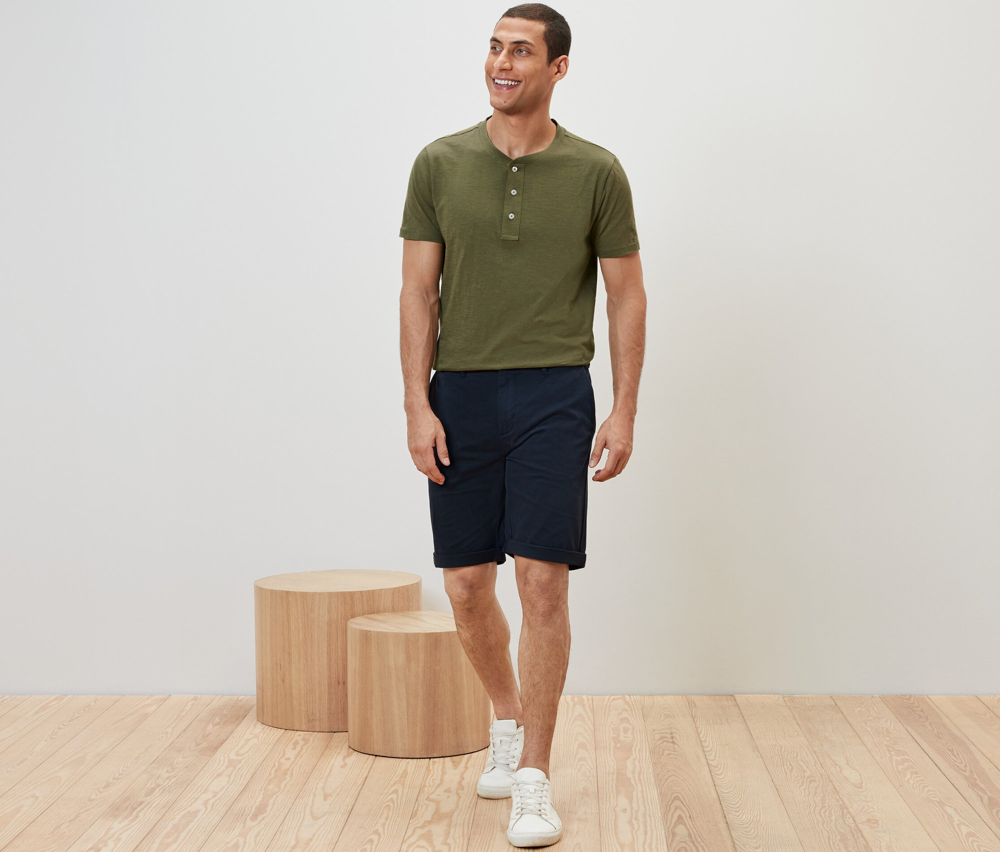 Mann trägt khaki T-Shirt und marineblaue Chino-Shorts.