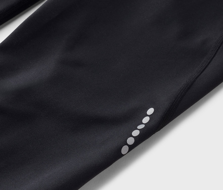 Nahaufnahme von schwarzen Tights mit reflektierenden Punkten am Bein.