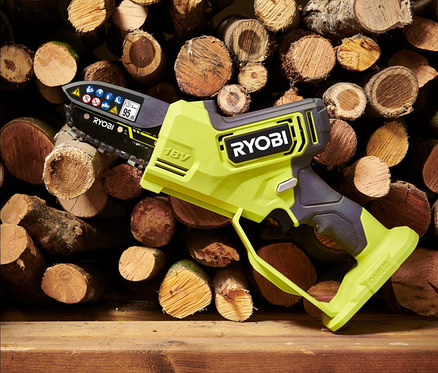 Eine RYOBI 18 V One+ Brushless Akku-Einhand-Kettensäge liegt auf einem Holzregal vor einem Stapel Brennholz.