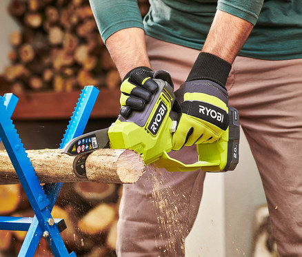 Mann sägt ein Stück Holz mit einer RYOBI 18 V One+ Brushless Akku-Einhand-Kettensäge.