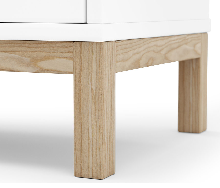 Detailansicht des unteren Teils eines weißen Wäschekorbregals mit Holzbeinen.