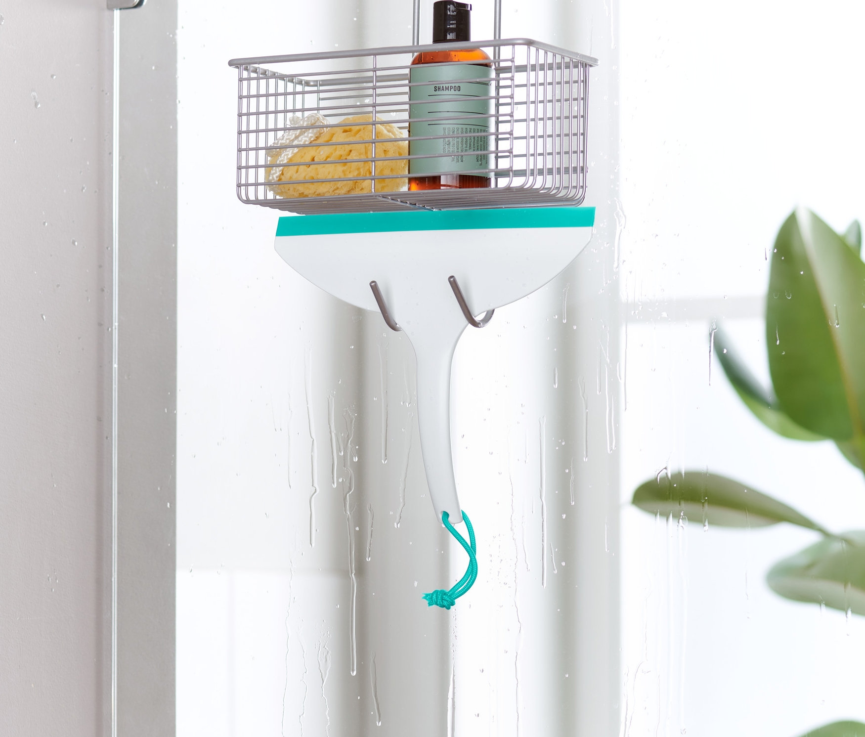 Ein Badwischer hängt an einer Duschkabinentür.