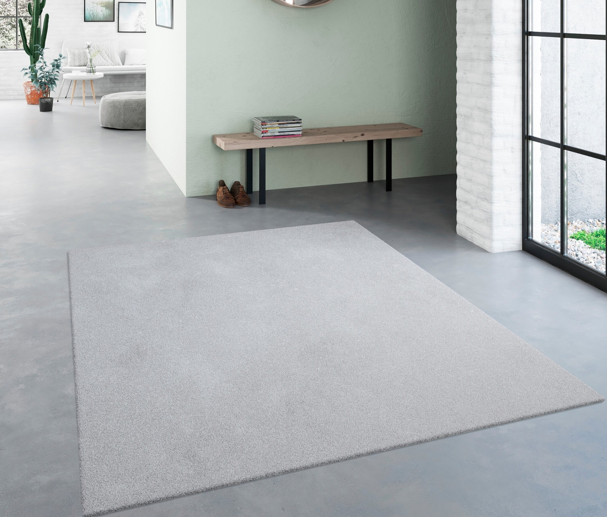 Ein hellgrauer Teppich »Mellow« liegt in einem Flur.