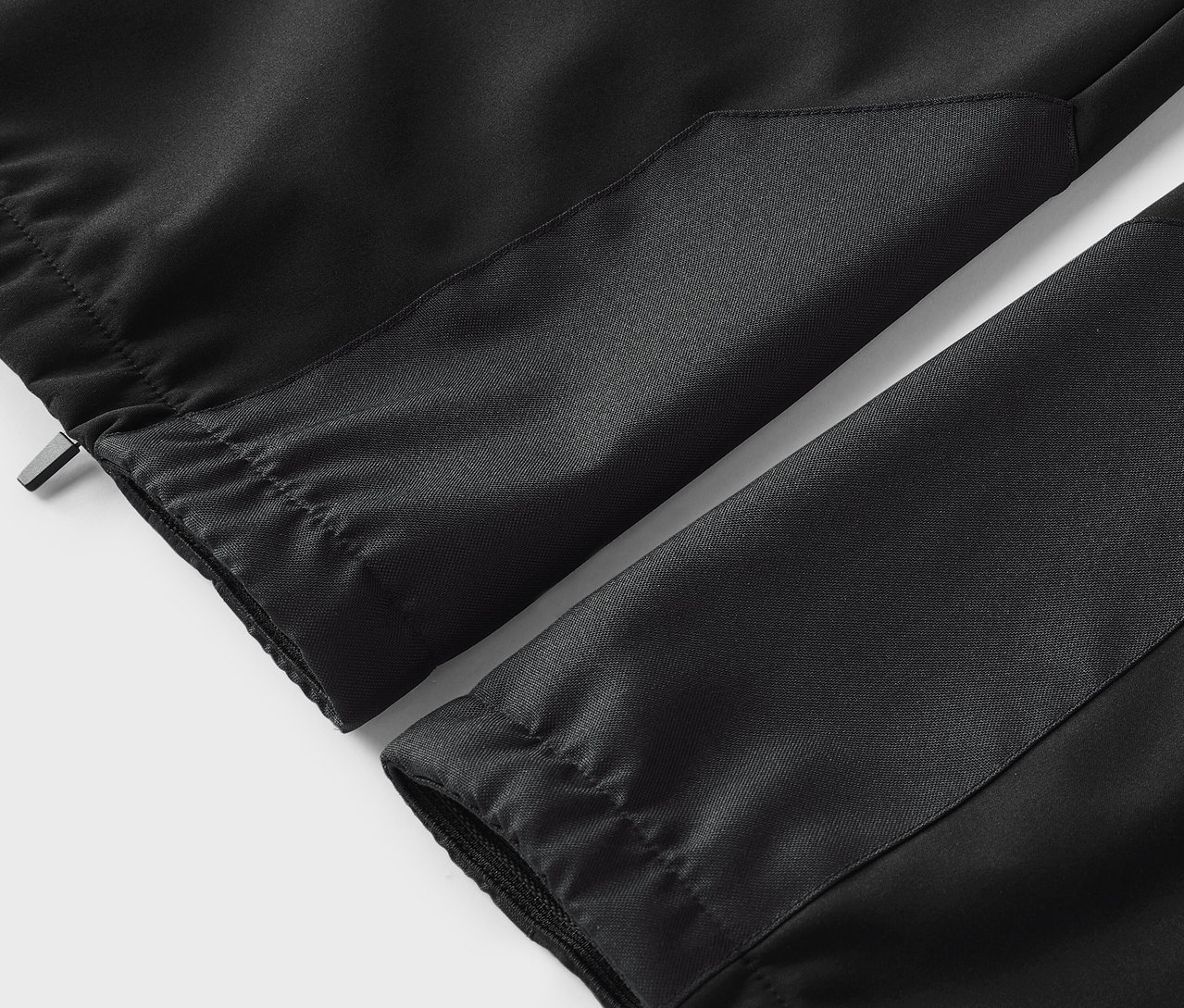 Detailaufnahme einer schwarzen Hose mit elastischem Bund und Manschetten.