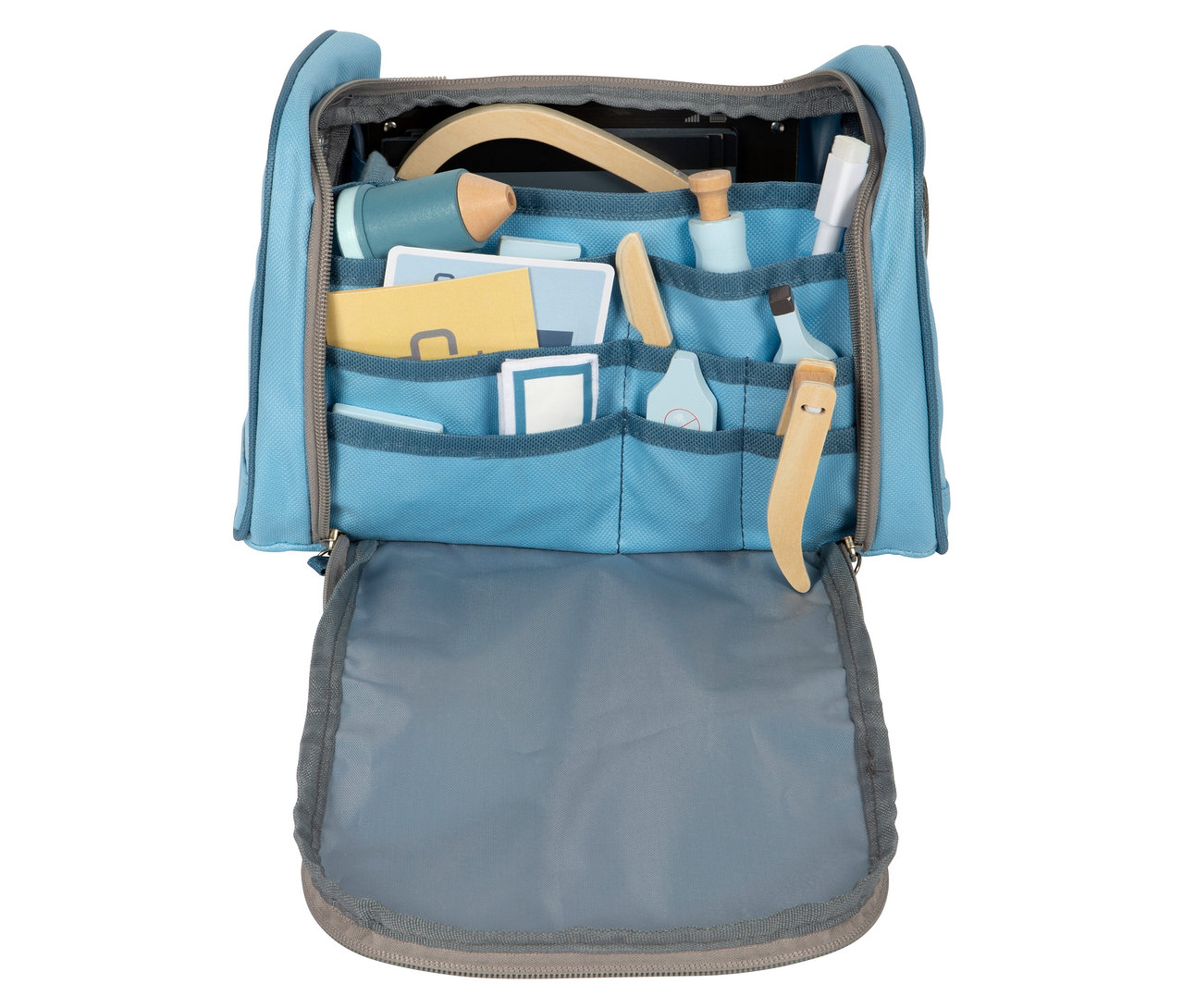 Offene, hellblaue Tierarzt-Tasche mit mehreren Fächern, gefüllt mit Spielzeug-Arztwerkzeugen, darunter ein Stethoskop, von small foot.