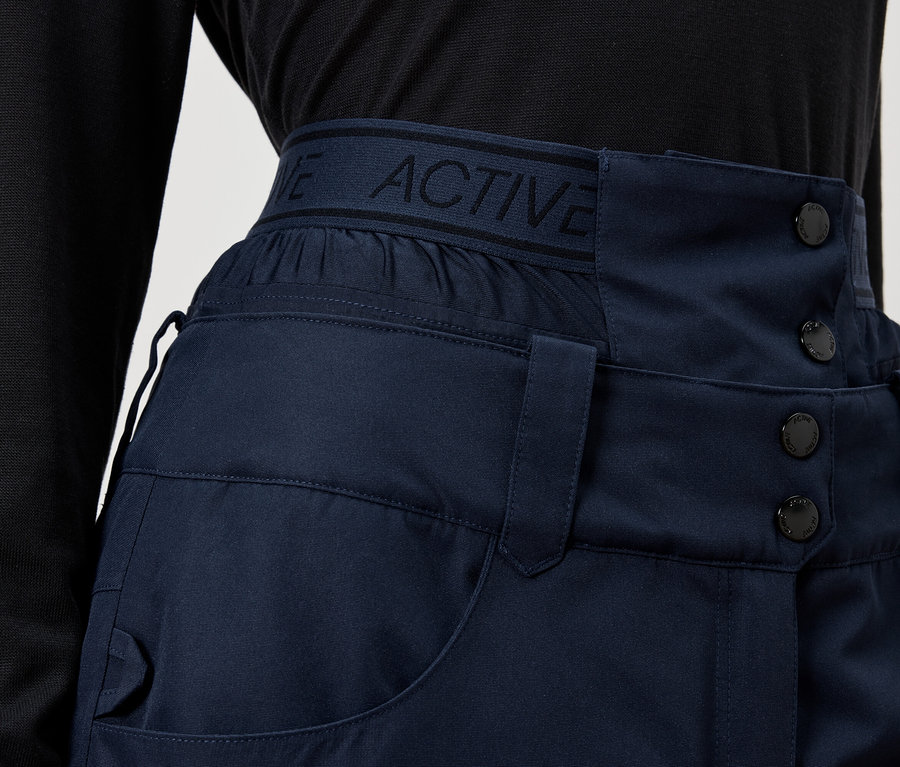 Detail einer marineblauen Hose mit hohem Bund und Knöpfen.