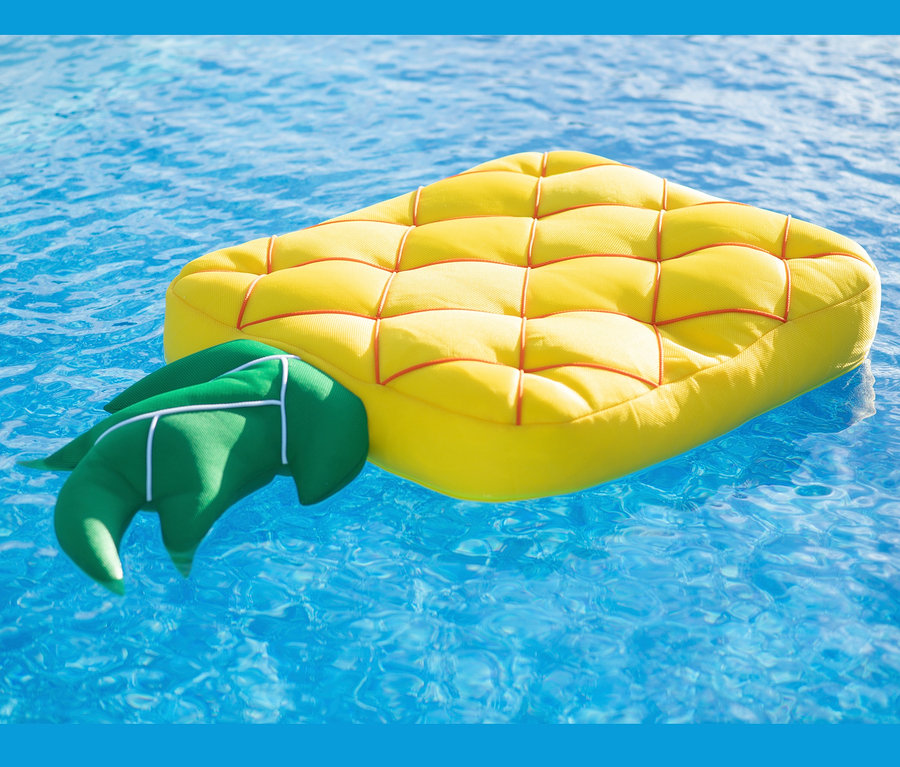 Gelbe Pool Buddy Ananas Schwimmmatratze schwimmt auf blauem Wasser.