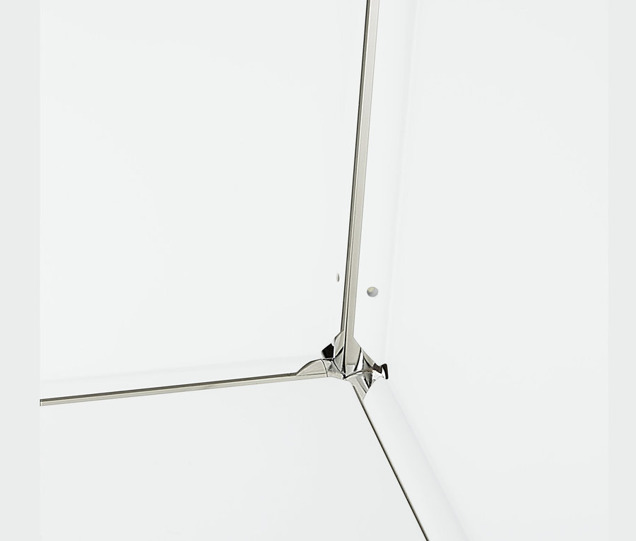 Detail einer Ecke eines weißen Metall-Sideboards mit 2 versetzbaren Klappenfächern.