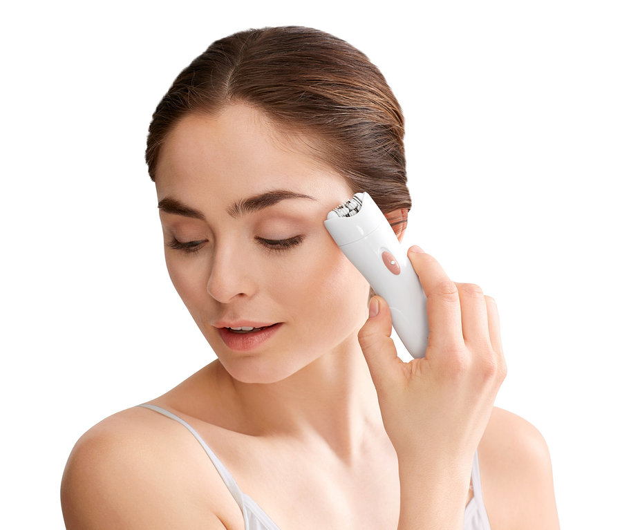 Frau verwendet einen weißen Gesichtsepilierer.