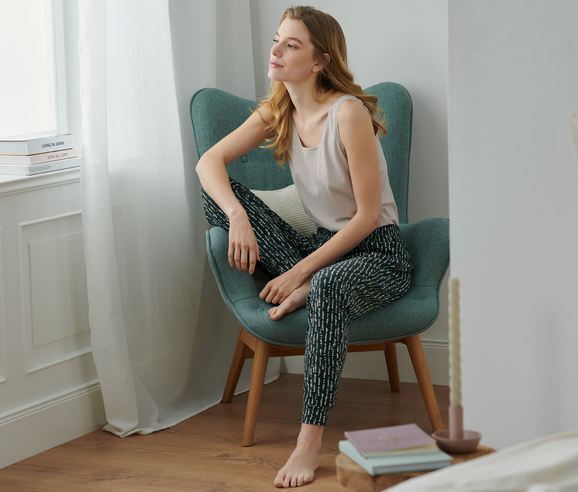 Frau sitzt im Sessel und trägt eine Relaxhose.