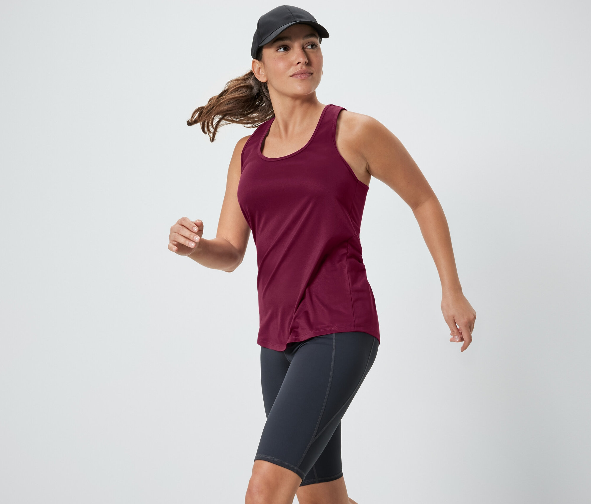 Frau läuft in einem pinkfarbenen Funktionstop aus einem zweiteiligen Set.