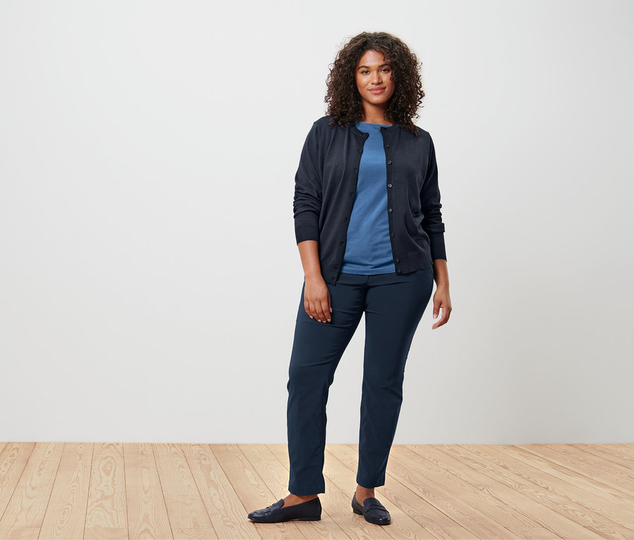 Frau trägt blaues Halbarmshirt und Strickjacke.