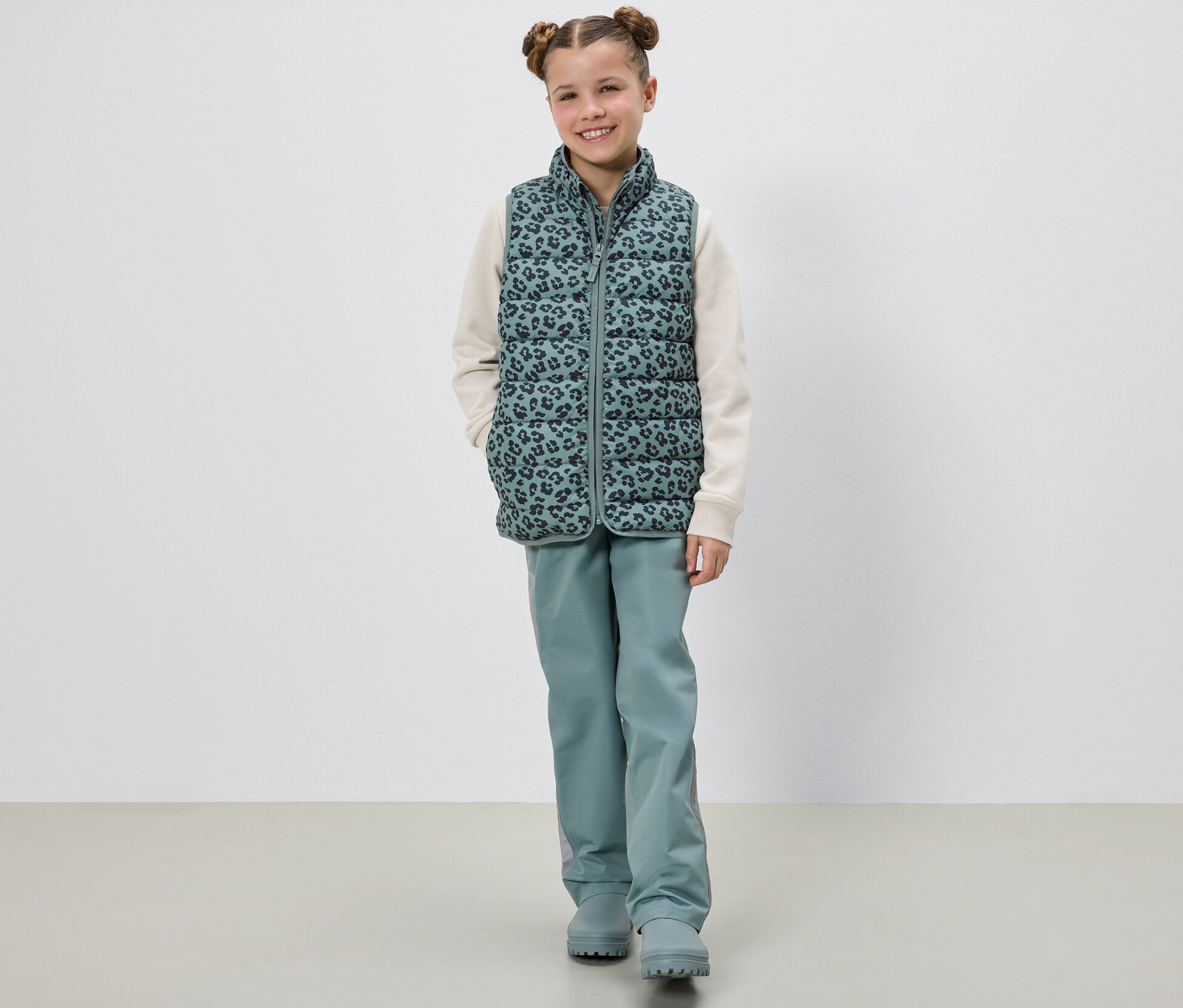 Mädchen posiert in Kinder-Steppweste.