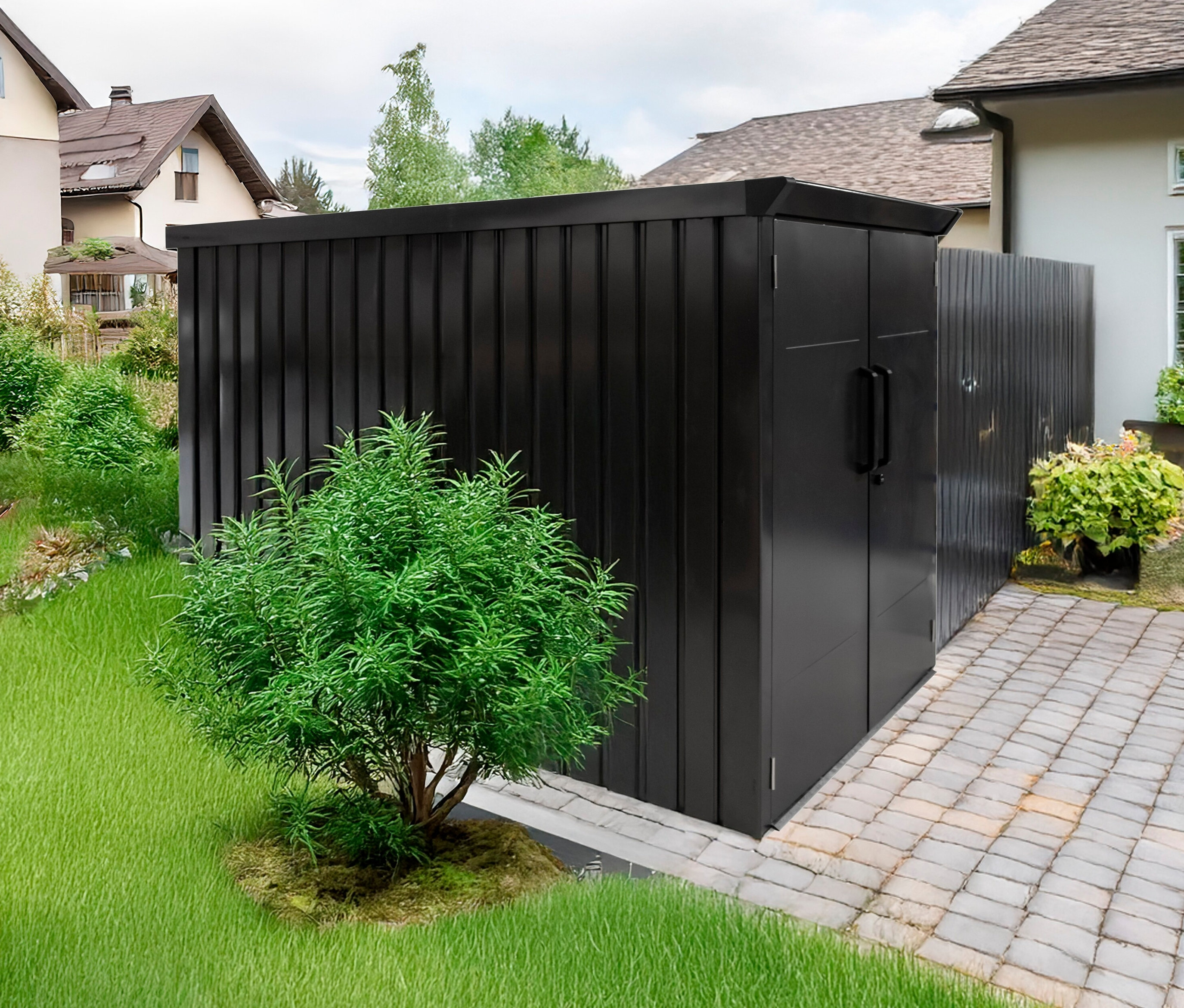 Eine schwarze Fahrradbox steht auf einem gepflasterten Weg neben einem grünen Rasen.