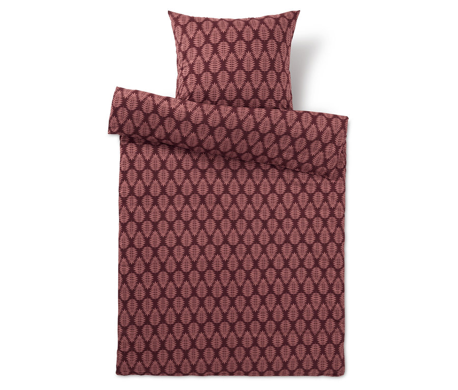 Weinrote Bettwäsche mit Blättermuster und Kissen.