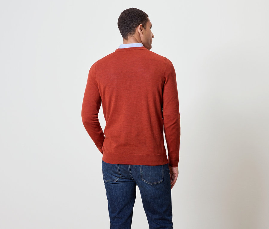 Mann von hinten, trägt einen orangefarbenen Pullover und blaue Jeans.