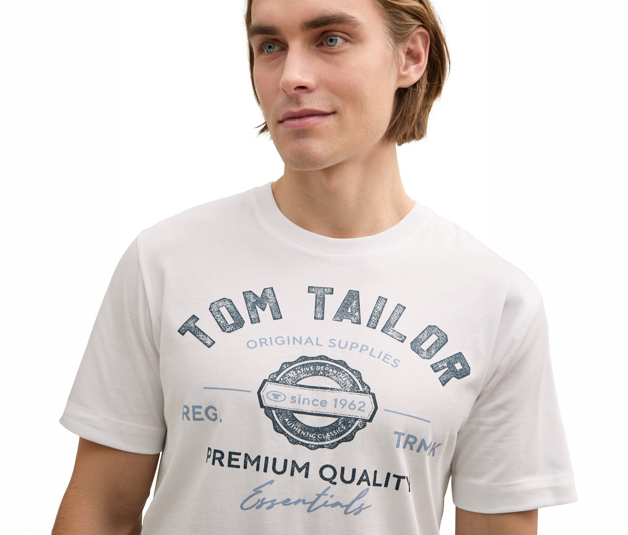 Mann trägt ein weißes Tom Tailor T-Shirt mit Logo.
