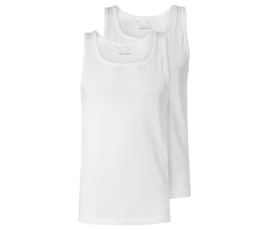 Zwei weiße Tanktops liegen übereinander.