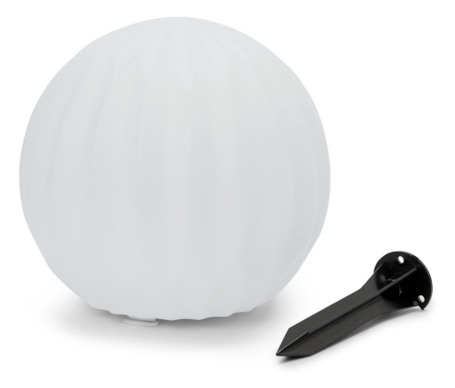 Eine weiße kugelförmige Lampe liegt neben einem schwarzen Erdspieß.