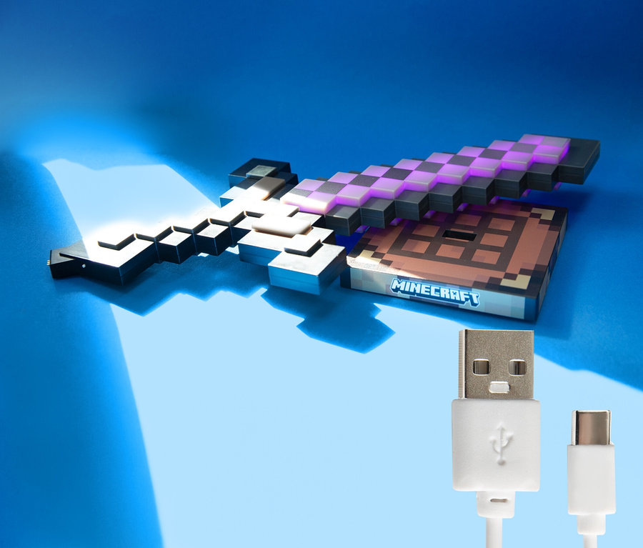 Ein Minecraft-Schwert und ein Minecraft-Tisch liegen auf einem blauen Hintergrund. Ein USB-Kabel befindet sich im Vordergrund.