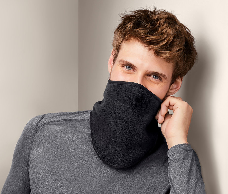 Mann mit braunen Haaren und blauen Augen trägt einen schwarzen Kälteschutzkragen.