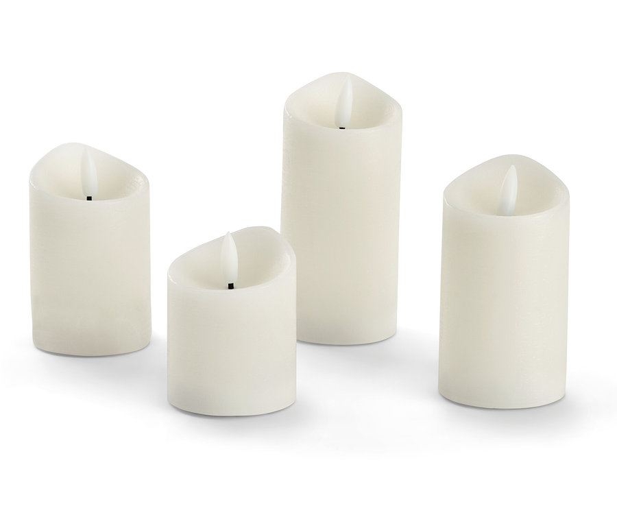 Vier creme LED-Echtwachskerzen.