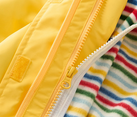 Detailaufnahme einer gelben 3-in-1-Kinder-Outdoorjacke mit Reißverschluss und gestreifter Innenschicht.