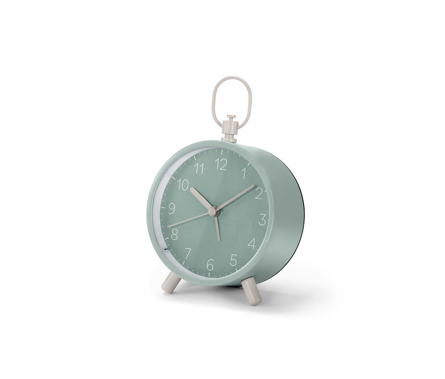 Ein mintgrüner Analoger Designwecker steht auf einer weißen Oberfläche.