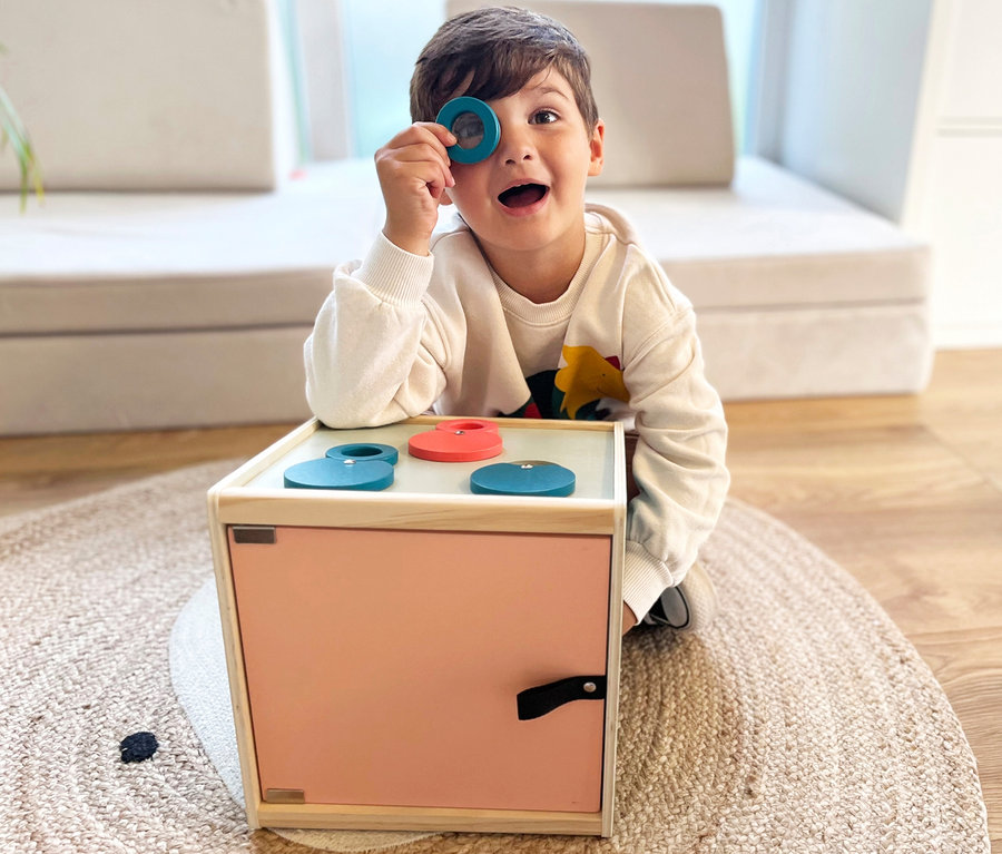 Junge schaut durch blaue Form aus small foot Sinnes-und-Fühl-Box »Sensory«.