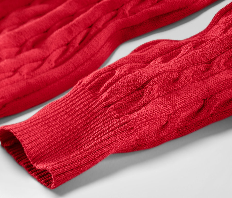 Detailansicht eines roten Zopfstrickpullovers.