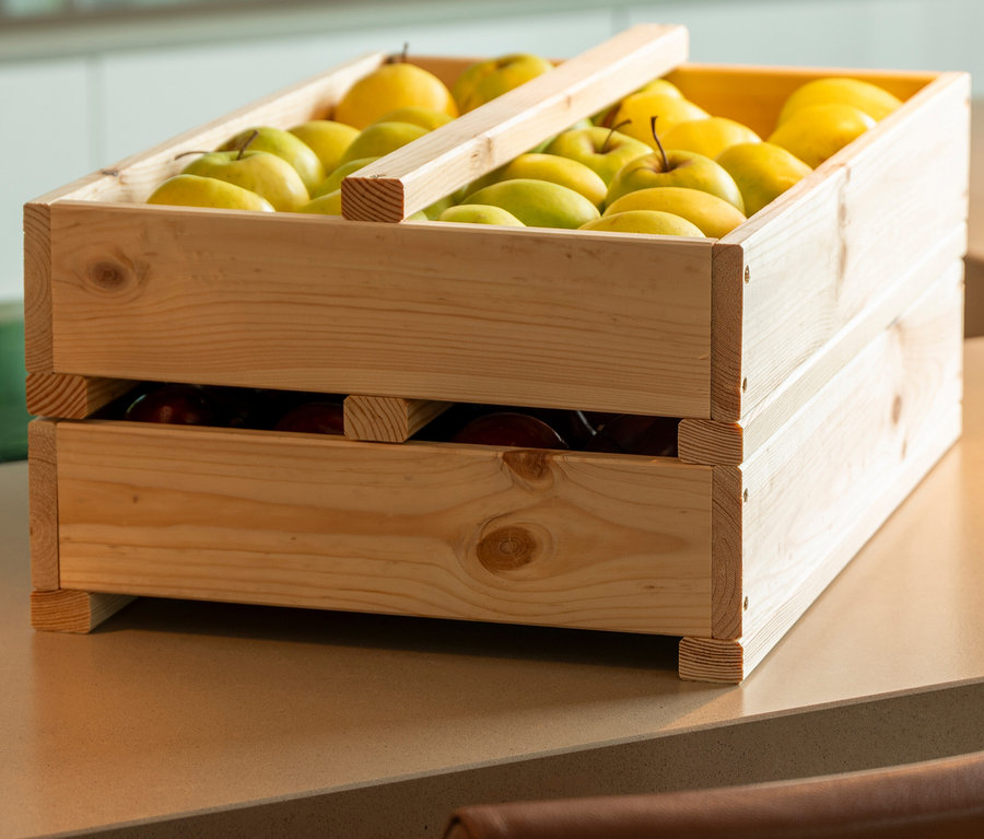 Ein hölzernes Vorratsregal gefüllt mit gelben Äpfeln und Birnen.
