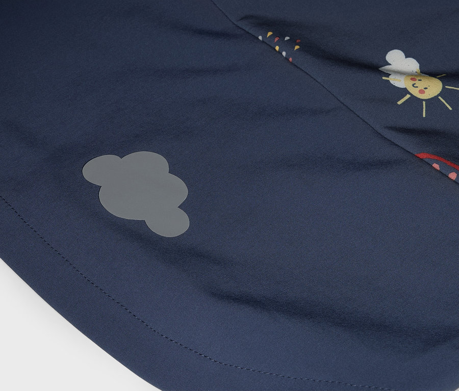 Nahaufnahme eines dunkelblauen Stoffes mit einem grauen Wolken-Aufnäher und einem Sonne-Gesicht-Aufdruck.