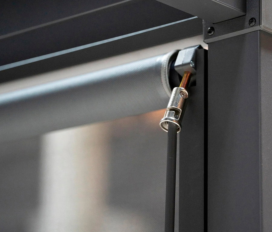 Nahaufnahme einer heruntergelassenen, grauen Rollo-Markise mit schwarzer Zugschnur und silberfarbener Aufhängung.