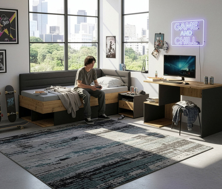 Ein Jugendlicher sitzt mit Controller auf einem Bett neben dem Roba Schreibtisch »Marvin«.