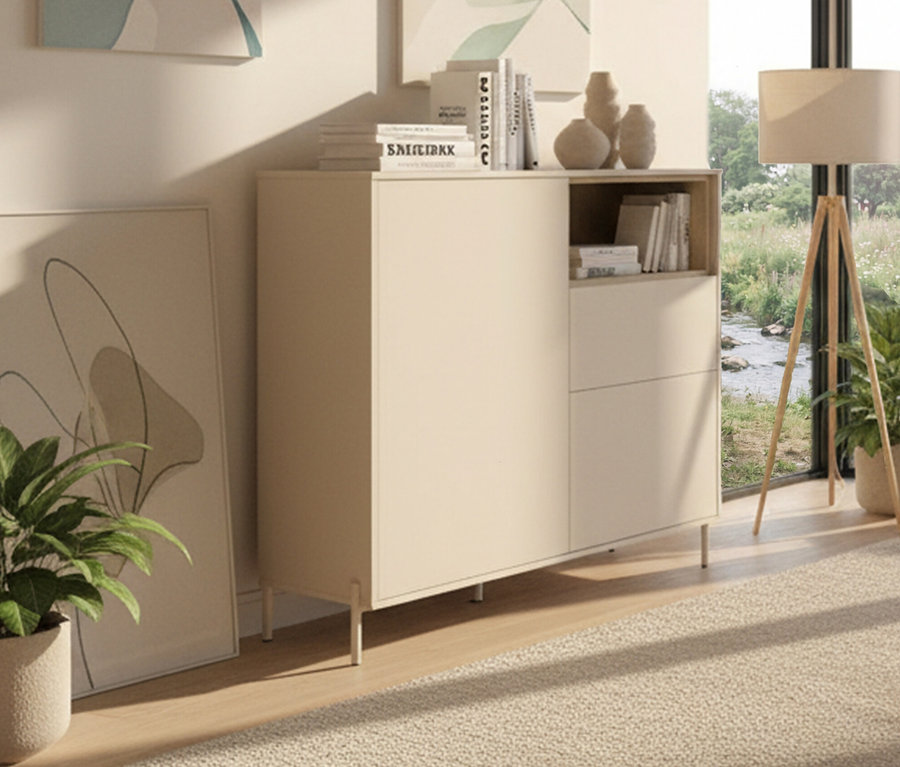 Ein »Hygge« Highboard mit 2 Türen in Kaschmir-Weiß steht im Raum, dekoriert mit Büchern und Vasen. Eine Zimmerpflanze steht daneben.