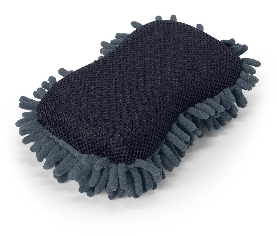 Ein grauer Schwamm mit blauen Mikrofaser-Fransen liegt auf einem weißen Hintergrund.