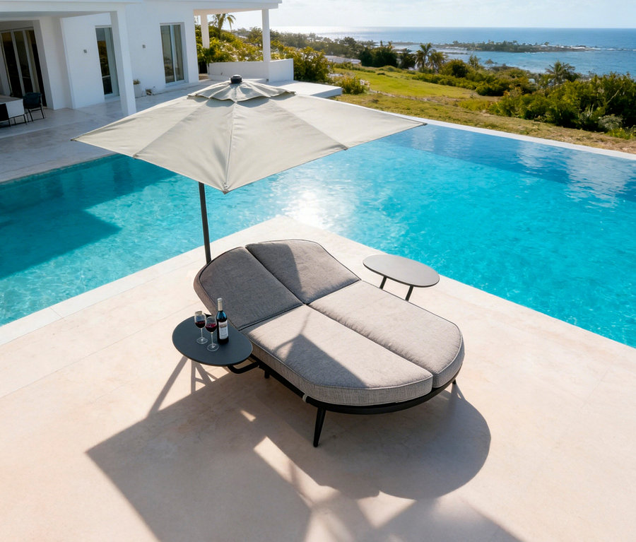 Ein grauer Liegestuhl mit Sonnenschirm steht neben einem Pool. Zwei Weingläser und eine Flasche Wein stehen auf einem Tisch.
