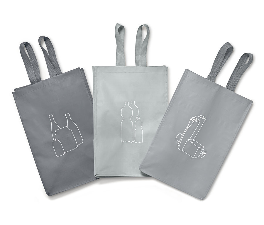 Drei graue Recycling-Abfall-Sortiertaschen mit grauen Griffen und weißen Bildern von Recyclingmaterialien.