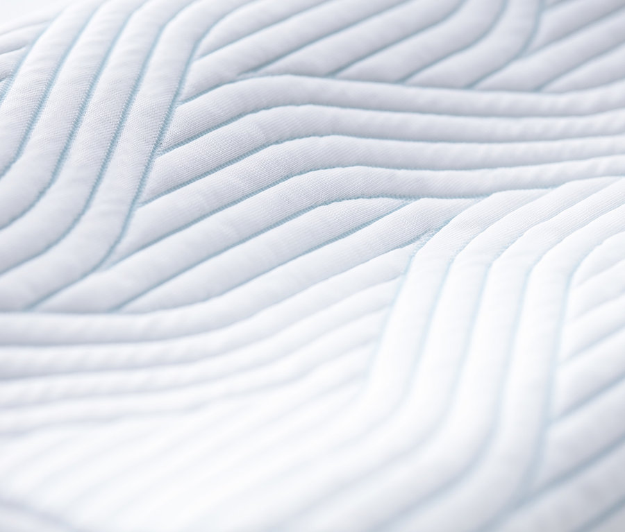 Nahaufnahme eines weißen TEMPUR® Kissens mit blauen Streifen.