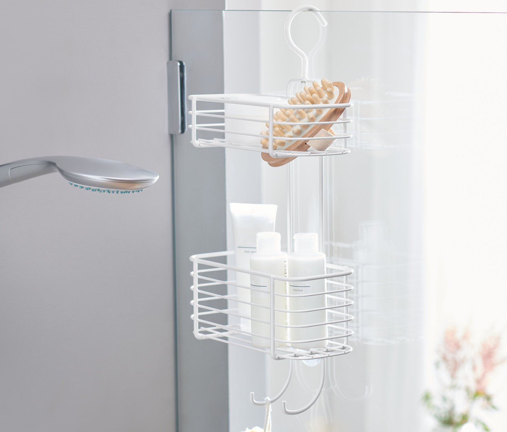 Ein Duschregal zum Aufhängen mit Bürste, Flaschen und Schwamm.