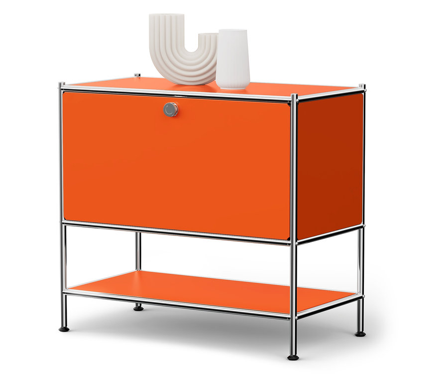 Ein orangefarbener Schrank mit silbernem Rahmen und zwei weißen Vasen darauf.