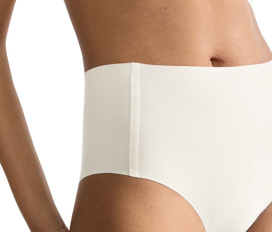Nahaufnahme einer Frau, die einen hochtaillierten, weißen Slip und ein passendes Oberteil trägt.