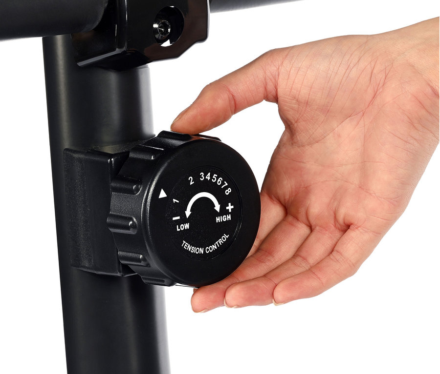 Eine Hand justiert den Widerstand an einem Heimtrainer 2.2 in Holzoptik.