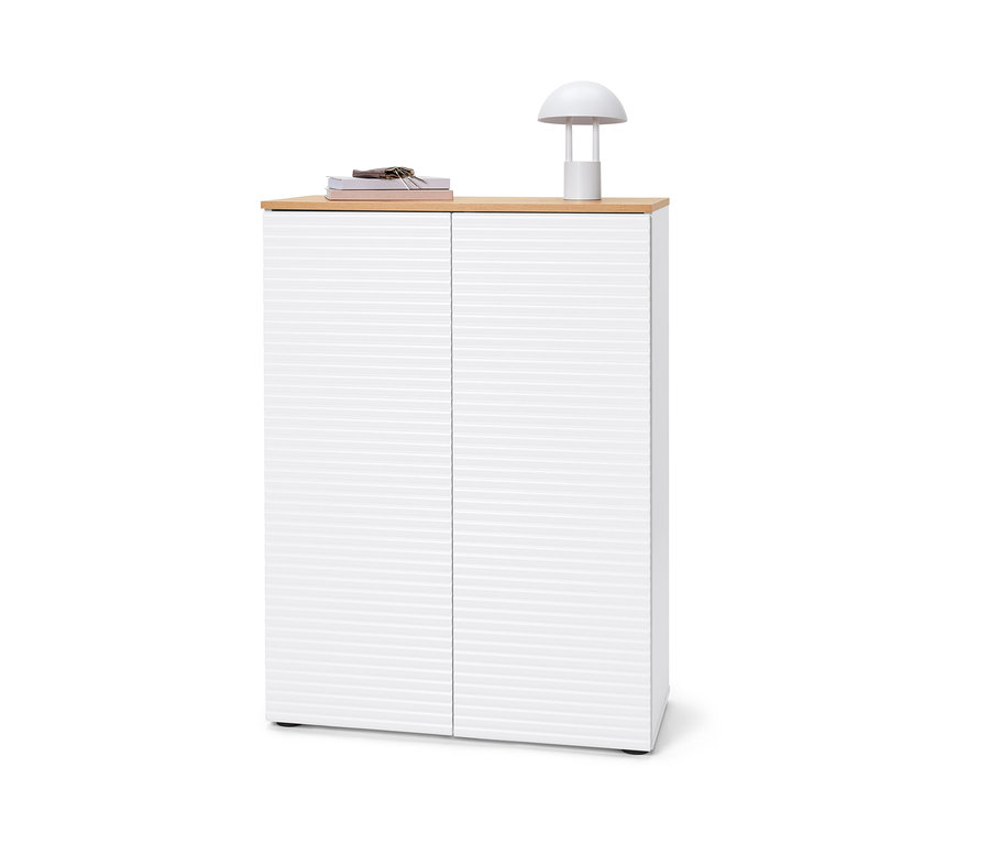 Schuhschrank mit Büchern, Schlüsseln und Lampe oben drauf.